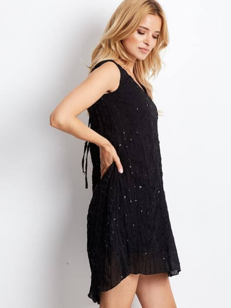 Black sequined dress with a tie at the back.
